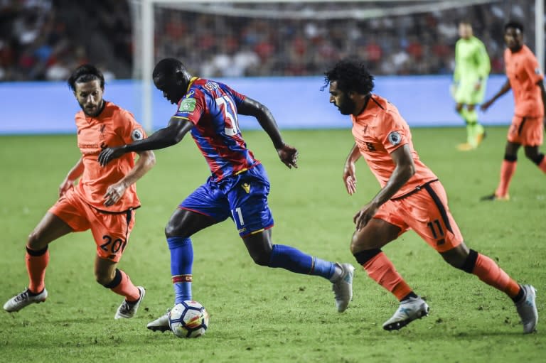 Jeffrey Schlupp (C) of Crystal Palace controls the ball between Adam Lallana (L) and Mohamed Salah (R) of Liverpool FC during a 2017 Premier League Asia Trophy fixture at Hong Kong Stadium