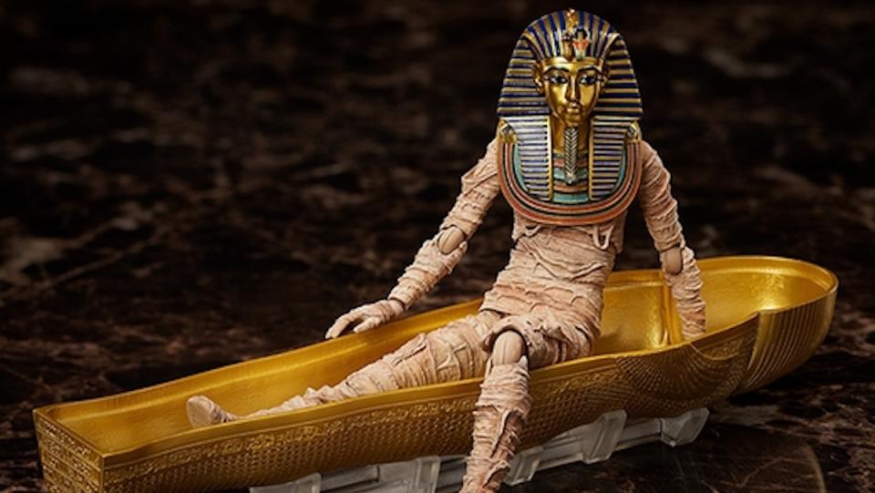 A king tut mummy figure with gold mask posed to be walking out of its coffin