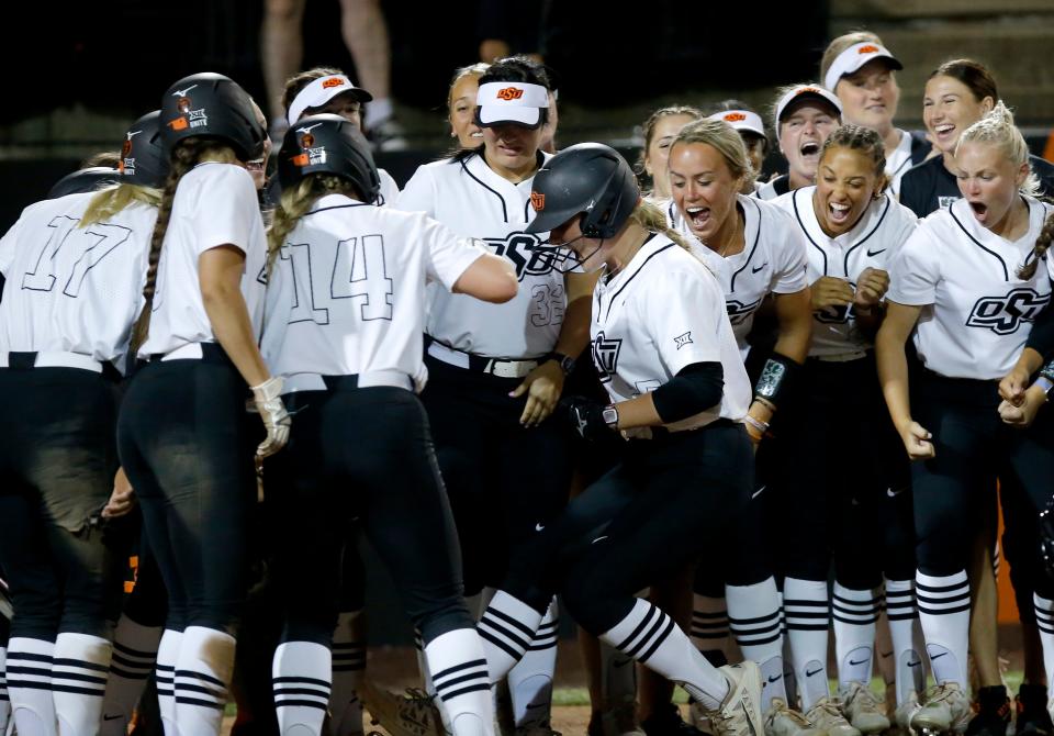 Oklahoma State celebrates as Julia Cottrill (25) comes home after hitting a grand slam during the Stillwater Regional in 2022 NCAA softball championship between Oklahoma State Cowgirls and Fordham University Rams at Cowgirl Stadium in Stillwater, Okla., Friday, May, 20, 2022. OSU won 12-0.