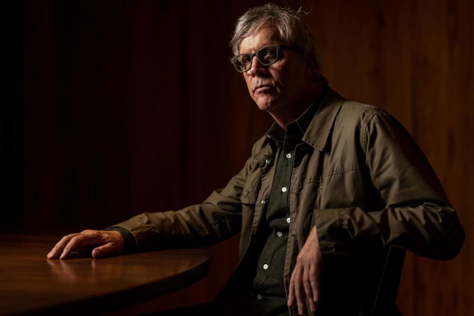 A man sits in a chair at a table.