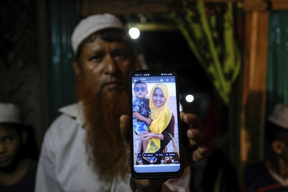 Rohingya refugee Muhammad Ayub shows a photo of his daughter, Samira Begum, and her 6-year-old son, Tasin Ahmed, during an interview in his shelter at the Nayapara refugee camp in the Cox's Bazar district of Bangladesh, on March 7, 2023. Samira, her husband, Tasin and Tasin’s 9-month-old brother were on board a boat of about 180 Rohingya refugees that vanished in December 2022. (AP Photo/Mahmud Hossain Opu)
