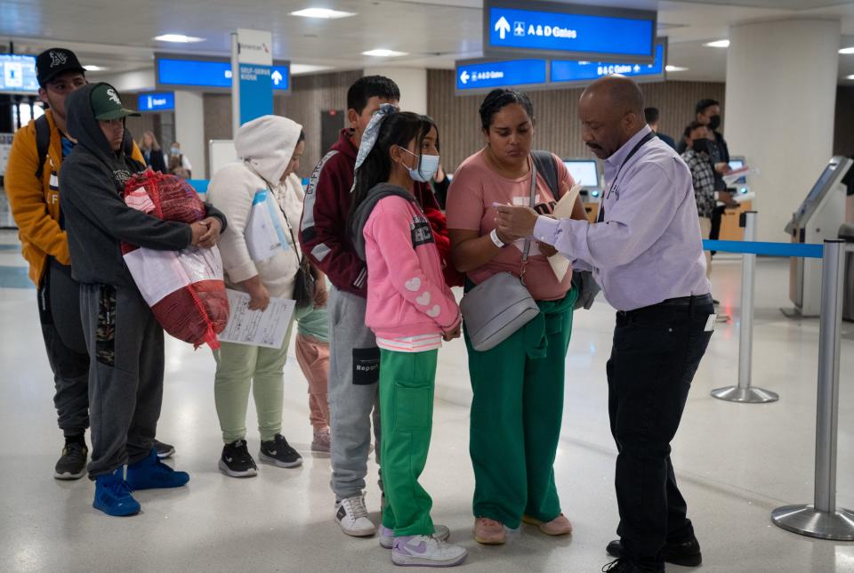 Migrants who were released in Tucson and bused to Sky Harbor International Airport in Phoenix, are assisted by a member of the PHX Customer Service Team (right) on Dec. 12, 2023. The experiences at the three busiest airports in the Southwest — Phoenix, San Antonio and San Diego — illustrate how years of coordination between local, state and federal agencies have created efficient processes meant to avoid the chaos and disruption playing out at other transportation hubs around the United States.