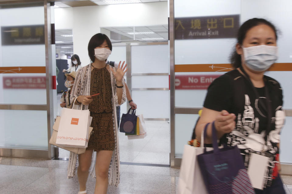 Participants walk through the entry gate during a mock trip abroad at Taipei Songshan Airport in Taipei, Taiwan, Tuesday, July 7, 2020. Dozens of would-be travelers acted as passengers in an activity organized by Taiwan’s Civil Aviation Administration to raise awareness of procedures to follow when passing through customs and boarding their plane at Taipei International Airport. (AP Photo/Chiang Ying-ying)