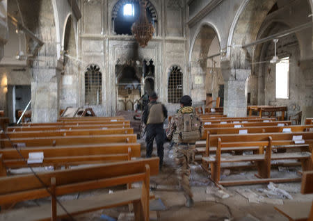 Iraqi special forces soldiers walk inside a church damaged by Islamic States fighters in Bartella, east of Mosul. REUTERS/Goran Tomasevic