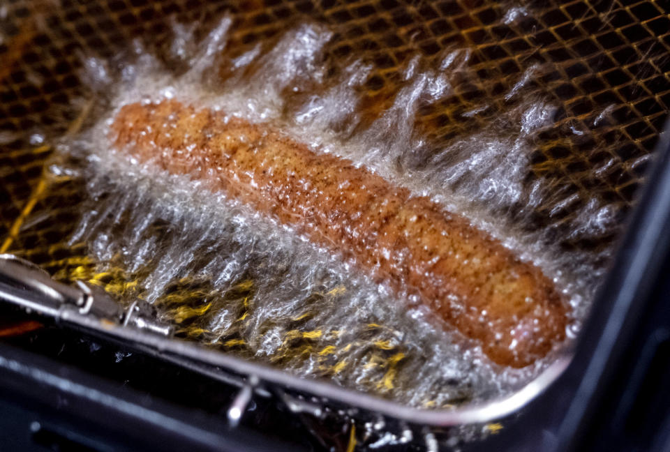 A vegan curry wurst is deep fried in a "Best Worscht in Town" sausage branch in Frankfurt, Germany, Wednesday, Sept. 13, 2023. An explosion of new types of plant-based “meat” — the burgers, nuggets, sausages and other cuts that closely resemble meat but are made from soybeans and other plants — is attracting customers all over the world. Even in Germany, where cities like Hamburg and Frankfurt have given their names to iconic meat dishes, plant-based meat is becoming more popular. (AP Photo/Michael Probst)