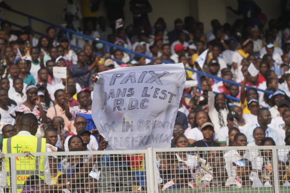 Faithful crowd the Martyrs' Stadium in Kinshasa, Democratic Republic of Congo for a meeting between Francis and young people, Thursday, Feb. 2, 2023. Francis is in Congo and South Sudan for a six-day trip, hoping to bring comfort and encouragement to two countries that have been riven by poverty, conflicts and what he calls a "colonialist mentality" that has exploited Africa for centuries. Writing in French reads "Peace in the east of the Democratic Republic of Congo". (AP Photo/Gregorio Borgia)