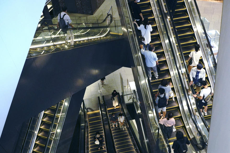 People take elevators at a shopping building in Tokyo Monday, Aug. 24, 2020. Japan's economy grew at an annual rate of 21.4% in the last quarter in a recovery from the shocks of the pandemic driven by both private spending and exports. (AP Photo/Eugene Hoshiko)