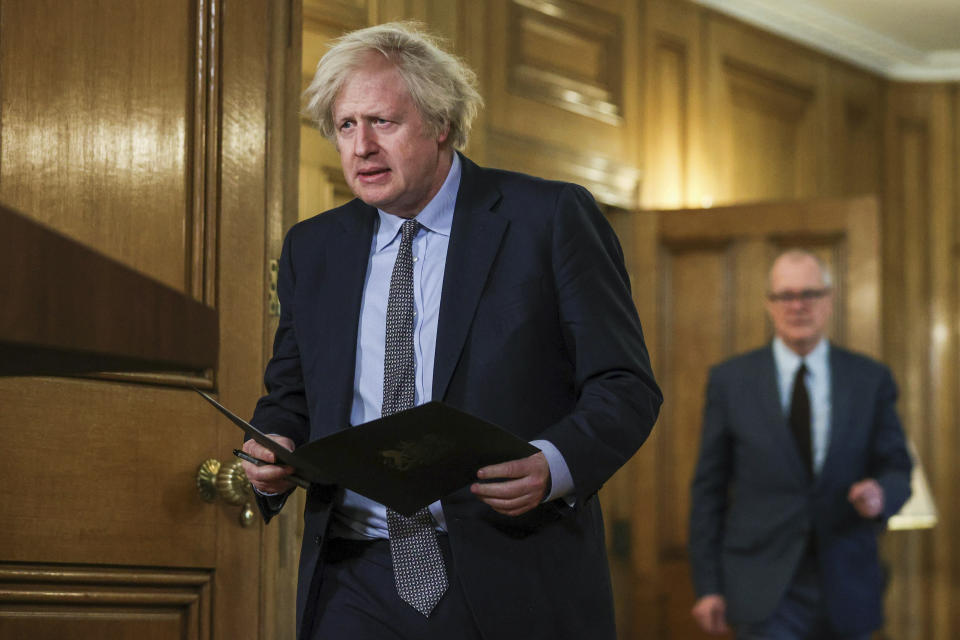 Britain's Prime Minister Boris Johnson arrives with British Chief Scientific Adviser Patrick Vallance, right, to attend a news conference at 10 Downing Street, on the first anniversary of Britain's coronavirus lockdown, in London, Tuesday March 23, 2021. The day is being called a national day of reflection to mark the anniversary of Britain's first coronavirus disease (COVID-19) lockdown. (Hannah McKay/Pool via AP)