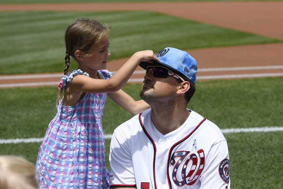 FILE - In this June 16, 2019, file photo, Washington Nationals' Ryan Zimmerman has his cap adjusted by his daughter Mackenzie before a baseball game against the Arizona Diamondbacks in Washington. Zimmerman has been offering his thoughts, as told to AP in a diary of sorts, while waiting for baseball to return. (AP Photo/Nick Wass, File)