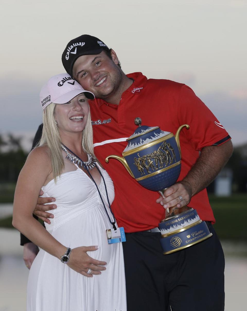 Patrick Reed poses with his wife Justine and The Gene Sarazen Cup after winning the Cadillac Championship golf tournament Sunday, March 9, 2014, in Doral, Fla. (AP Photo/Wilfredo Lee)