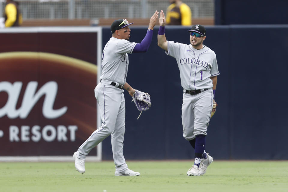 Colorado Rockies' Yonathan Daza, left, and Garrett Hampson, right, celebrate after defeating the San Diego Padres in a baseball game Sunday, June 12, 2022, in San Diego. (AP Photo/Mike McGinnis)