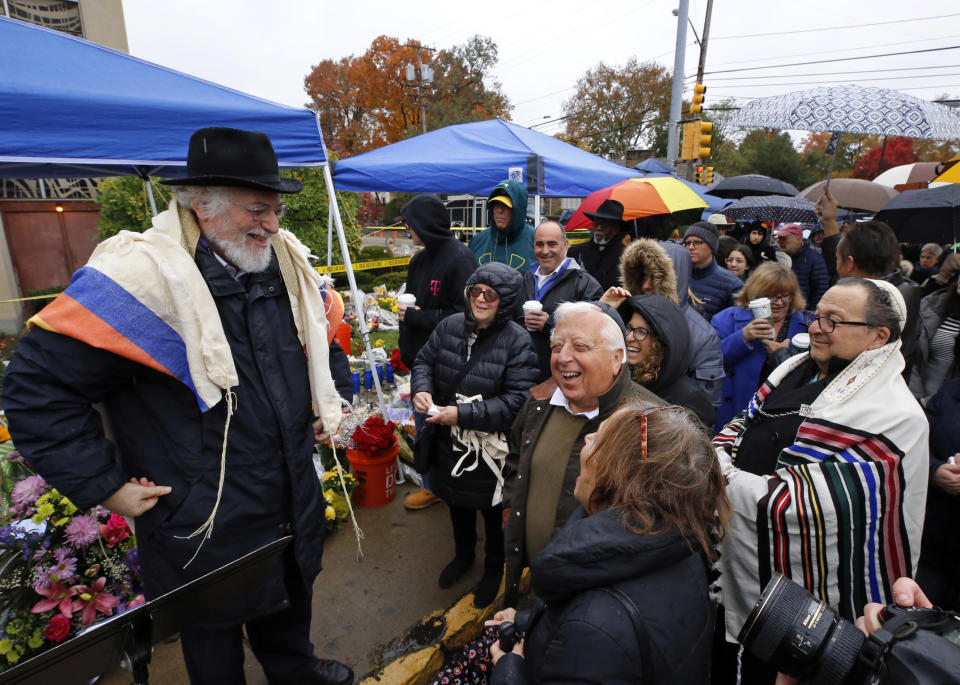 Rabbi Chuck Diamond, left, a former Rabbi at the Tree of Life Synagogue, shares a laugh with worshipers before leading a Shabbat service outside the Tree of Life Synagogue, Saturday, Nov. 3, 2018 in Pittsburgh. About 100 people gathered in a cold drizzle for what was called a "healing service" outside the synagogue that was the scene of a mass shooting a week ago. (AP Photo/Gene J. Puskar)