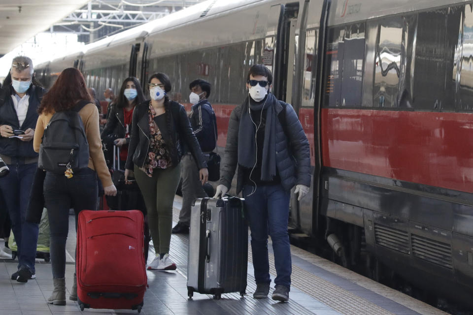 People disembark from train in Rome that has just arrived from Milan on Monday.