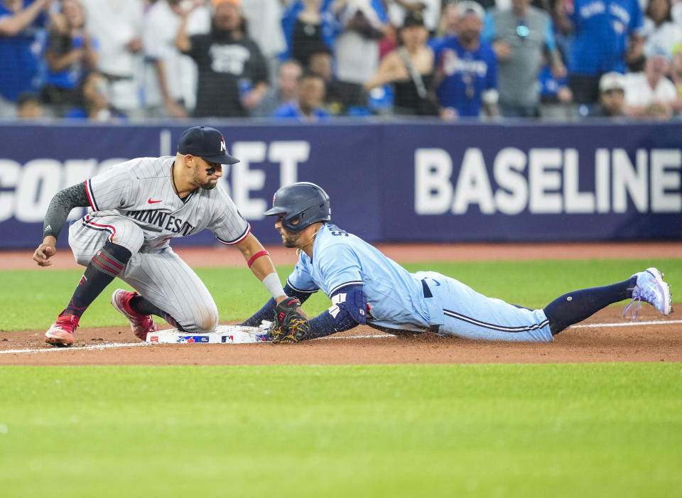 Toronto Blue Jays' George Springer slides safely into third as Minnesota Twins third baseman Royce Lewis tries to make the tag during the sixth inning of a baseball game Friday, June 9, 2023, in Toronto. Springer had hit an RBI double, and advanced to third. (Mark Blinch/The Canadian Press via AP)