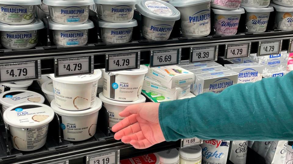 PHOTO: Stuart Dryden reaches for a store-label cream cheese at a grocery store , Feb. 21, 2024, in Arlington, Va. (Chris Rugaber/AP)