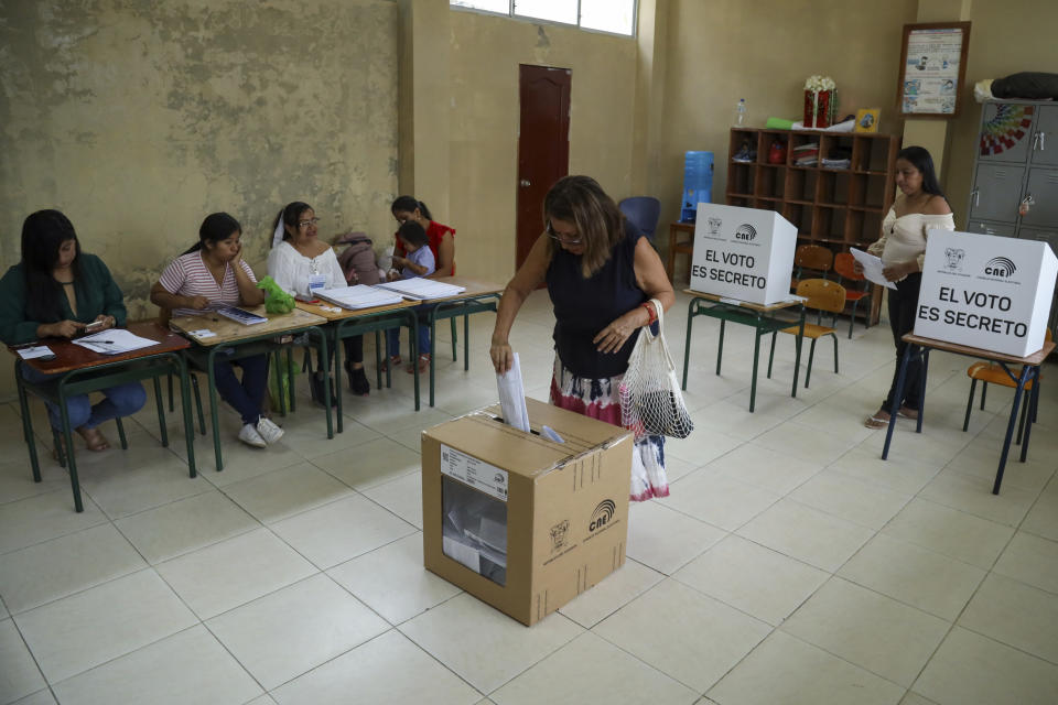 A voter casts her ballot during referendum proposed by President Daniel Noboa to endorse new security measures aimed at cracking down on criminal gangs fueling escalating violence, in Olon, Ecuador, Sunday, April 21, 2024. (AP Photo/Cesar Munoz)