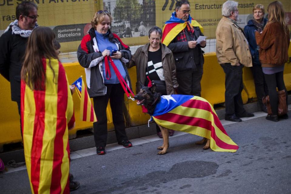 In this photo taken on Sunday, Jan. 12, 2014, people wear "estelada" flags as they wait to talk part in a pro-independence event in Barcelona, Spain. After years of mass protests by Catalans demanding the right to decide whether they want to break away from Spain and form a new European nation, the wealthy northeastern region’s lawmakers vote to ask permission from Spanish authorities to hold a secession referendum in November. The request eight months ahead of a Scottish independence referendum is certain to be denied by the central government in Madrid but is virtually guaranteed of generating even more separatist fervor. (AP Photo/Emilio Morenatti)