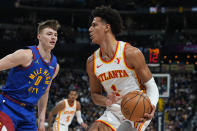 Atlanta Hawks forward Jalen Johnson (1) drives past Denver Nuggets guard Christian Braun (0) in the first half of an NBA basketball game Saturday, April 6, 2024, in Denver. (AP Photo/David Zalubowski)