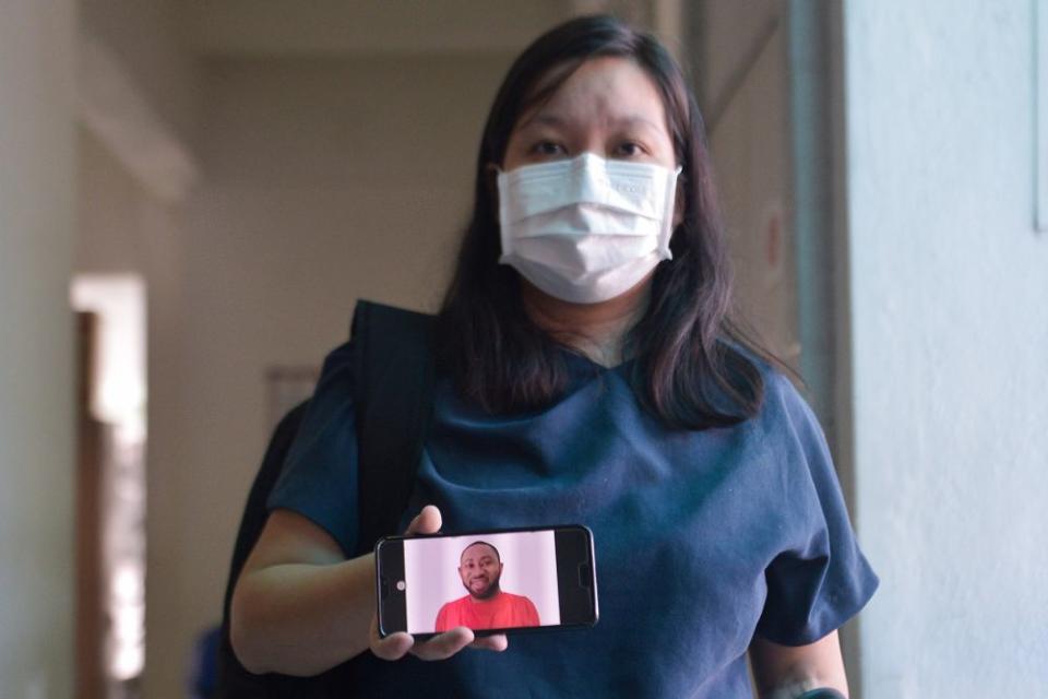 Simon Momoh's wife, Low Kar Hui, shows a picture of her husband on her phone at the Shah Alam High Court April 21, 2021. — Picture by Miera Zulyana