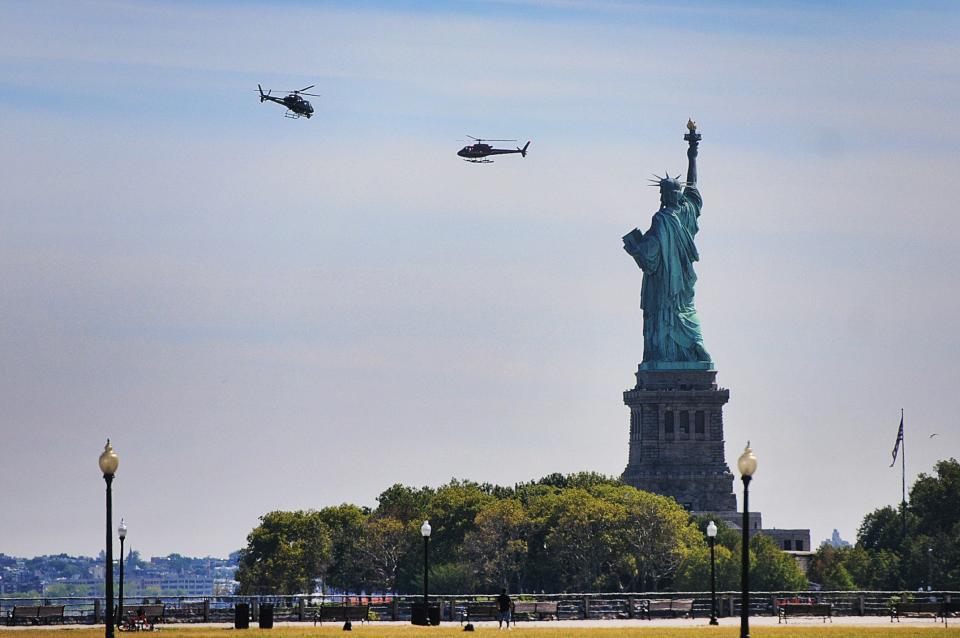 Two helicopters are seen hovering around the Statue of Liberty at Liberty State Park in Jersey City.