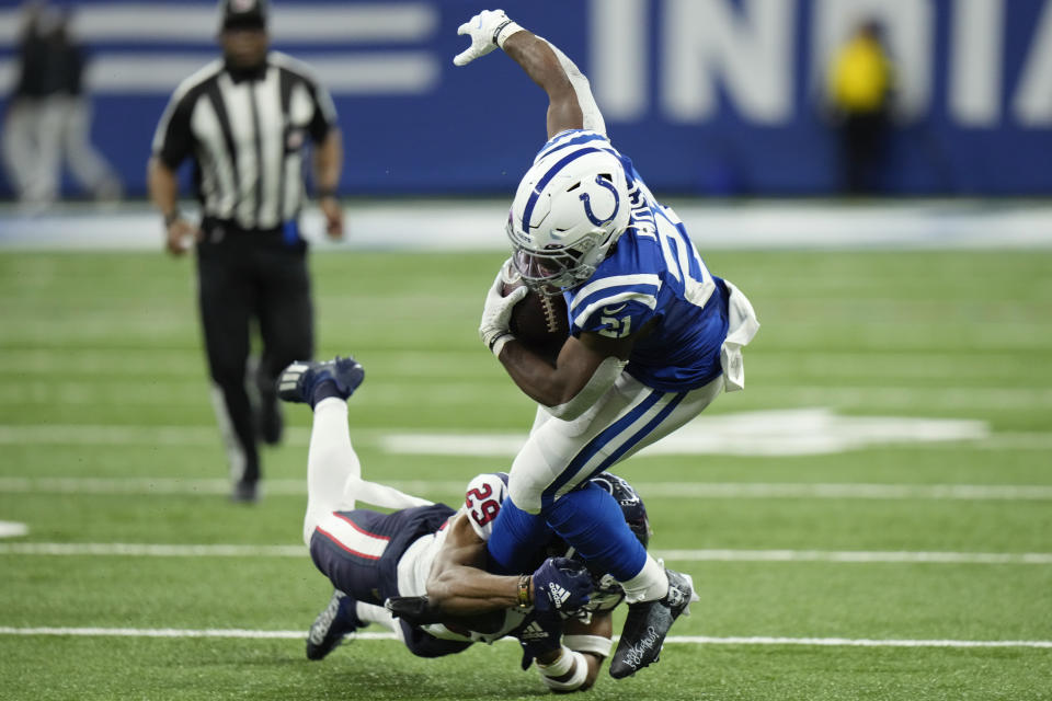 Indianapolis Colts running back Zack Moss (21) is tackled by Houston Texans safety M.J. Stewart during the first half of an NFL football game between the Houston Texans and Indianapolis Colts, Sunday, Jan. 8, 2023, in Indianapolis. (AP Photo/AJ Mast)