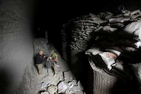 Members of the rapid response forces inspect a tunnel was used by Islamic State militants as an underground training camp in the hillside overlooking Mosul, Iraq, March 4, 2017. REUTERS/Alaa Al-Marjani