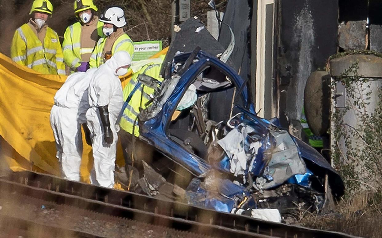 The blue car was split into several parts when it was hit by the train - London News Pictures Ltd