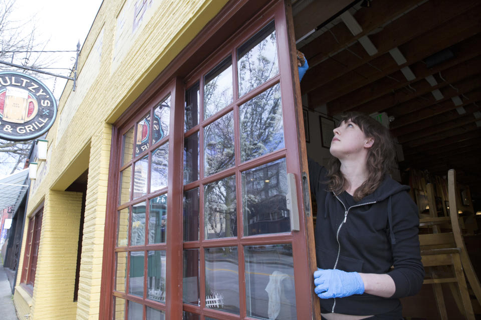 SEATTLE, WA - MARCH 24: Emily Scully, whose family owns Shultzys Bar and Grill stains trim around the windows on March 24, 2020 in Seattle, Washington. Washington State Governor Jay Inslee issued a Stay at Home order to begin March 25, requiring everyone in the state to stay home for at least two weeks and all non-essential businesses to shut down to help stem the spread of coronavirus (COVID-19). Scully says her family closed the business on March 16 when restaurants were ordered closed and they're using the time to paint and clean. (Photo by Karen Ducey/Getty Images)