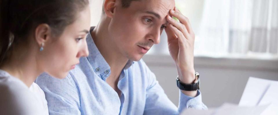 Man and woman reviewing student loan papers, looking to refinance to a lower rate.