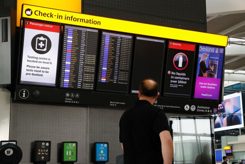 A man looks at a check-in information board at Heathrow Airport in London