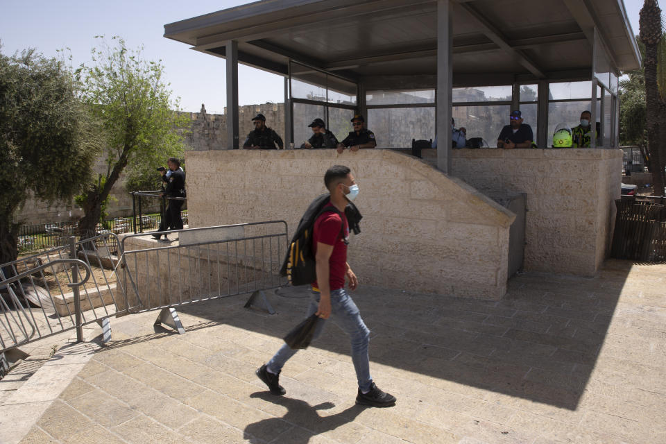 Israeli police watch a Muslim worshipper leaving the Old City of Jerusalem after Friday prayers during the Muslim holy month of Ramadan, on Friday, April 23, 2021. Israeli police say 44 people were arrested and 20 officers were wounded in a night of chaos in Jerusalem, where security forces separately clashed with Palestinians angry about Ramadan restrictions and Jewish extremists who held an anti-Arab march nearby. (AP Photo/Maya Alleruzzo)