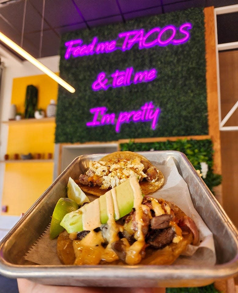 Two tacos are displayed beneath an LED sign at Taco Madre in Augusta.