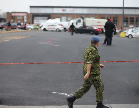 A member of Canada's armed forces walks past the scene of a hit and run of two soldiers in St. Jean sur Richelieu, Quebec, October 20, 2014. REUTERS/Christinne Muschi