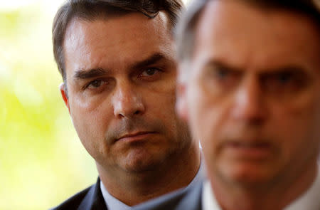 FILE PHOTO: Flavio Bolsonaro, son of Brazil's President Jair Bolsonaro is seen behind him at the transition government building in Brasilia, Brazil November 27, 2018. REUTERS/Adriano Machado/File photo