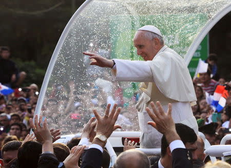 Pope Francis waves to a crowd of faithful after making a brief stop outside the women's jail "Good Pastor" (Buen Pastor) where a choir of inmates sang to him, in Asuncion, Paraguay, July 10, 2015. REUTERS/Lucas Nunez