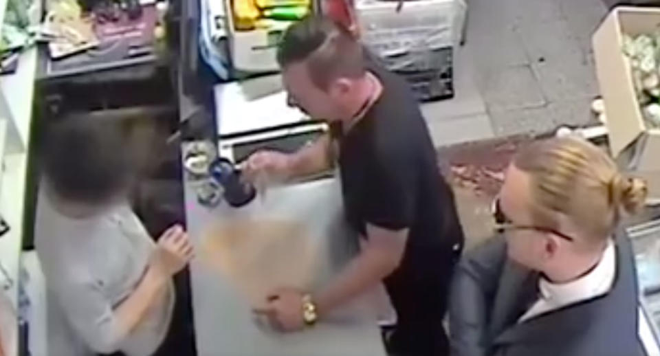 One of the men shows a Campsie shopkeeper a fake police badge and asks for $2000. Source: 7 News