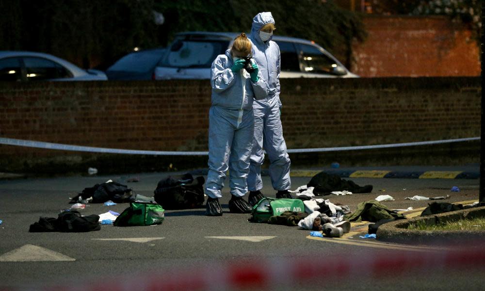 Forensics officers inspect the area outside Landor House, Camberwell, after four people were taken to hospital with stab wounds