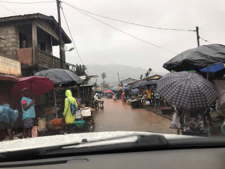 People walk in rainy streets of Freetown, Sierra Leone August 14, 2017 in this picture obtained from social media. Instagram/dawncharris via REUTERS