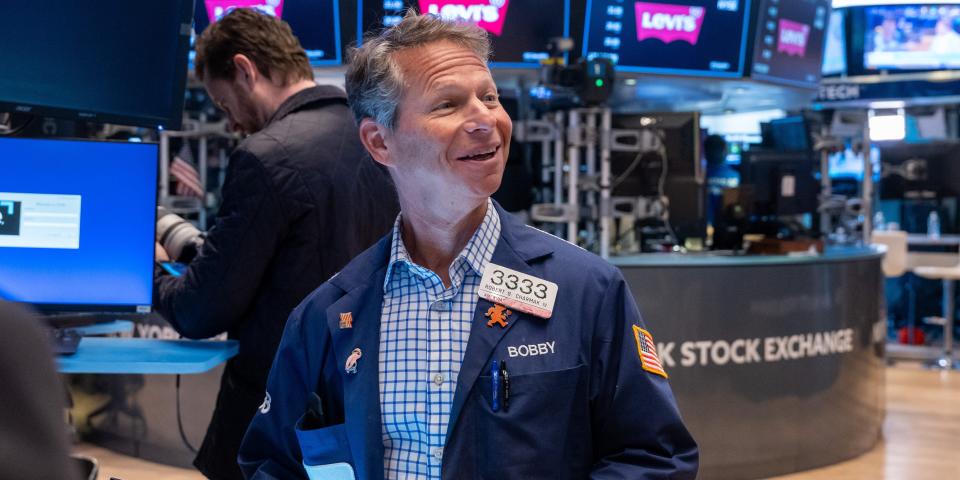 A smiling trader on the floor of the New York Stock Exchange.