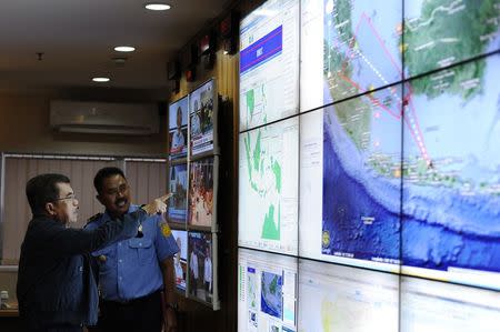 Indonesia's vice-president Jusuf Kalla (L) monitors progress in the search for AirAsia Flight QZ8501 during a visit to the National Search and Rescue Agency in Jakarta December 28, 2014. REUTERS/Antara Foto/Wahyu Putro A