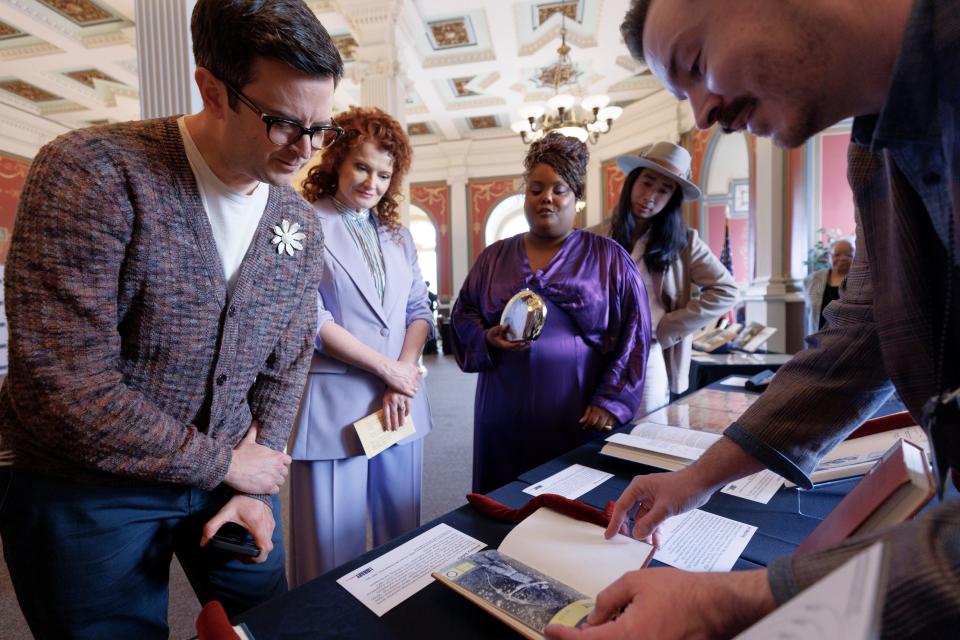 Cast members of the CBS comedy, "Ghosts," with Richie Moriarty (Pete) in the foreground, look over a special collections display at the Library of Congress, April 9, 2024.