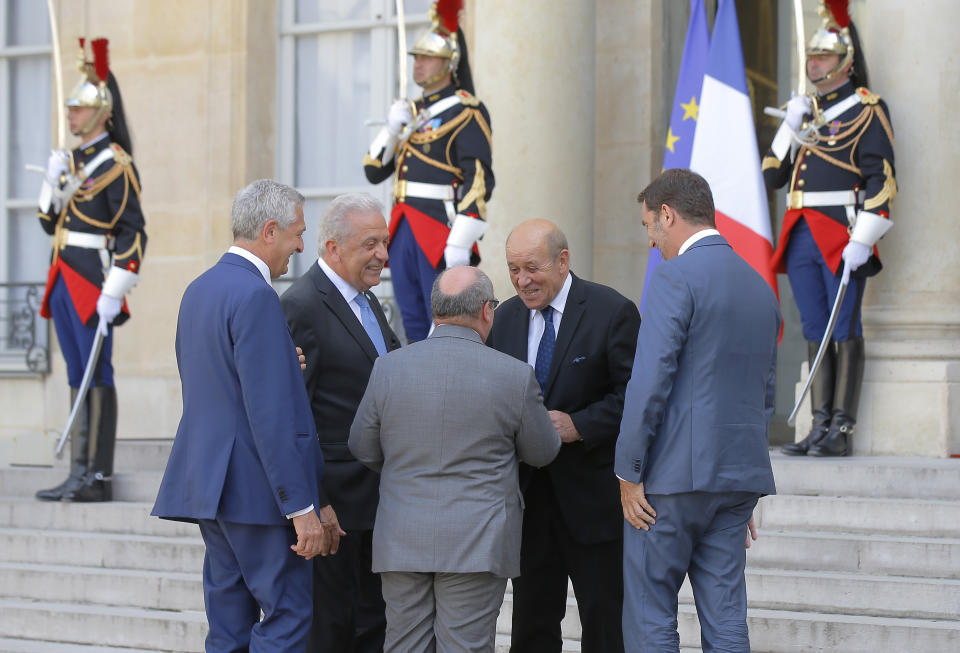 French Foreign Minister Jean-Yves Le Drian , 2nd right, welcomes Director of the United Nations Migration Agency Antonio Manuel de Carvalho Ferreira Vitorino, center, French Interior Minister Christophe Castaner, right, United Nations High Commissioner for Refugees (UNHCR) Filippo Grandi left, and European Commissioner for Migration and Home Affairs Dimitris Avramopoulos, 2nd left, for a meeting with French President Emmanuel Macron at the Elysee Palace in Paris, France, Monday, July 22, 2019. European ministers have met in Paris seeking unity on how to deal with migrants crossing the Mediterranean Sea. (AP Photo/Michel Euler)