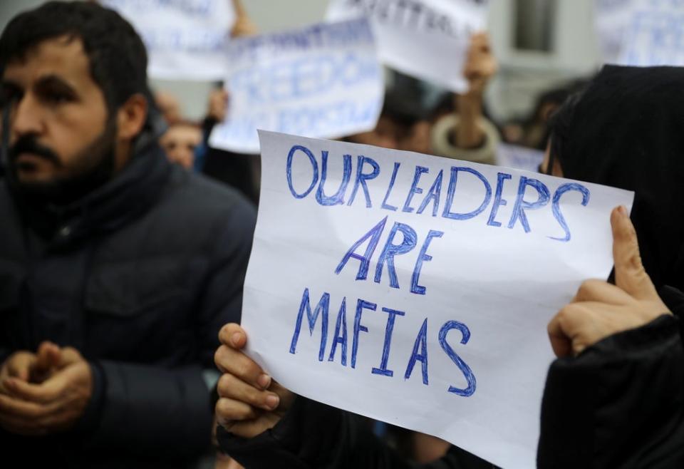 Migrants hold signs during a protest outside the transport and logistics centre in Bruzgi on the Belarusian-Polish border (REUTERS)