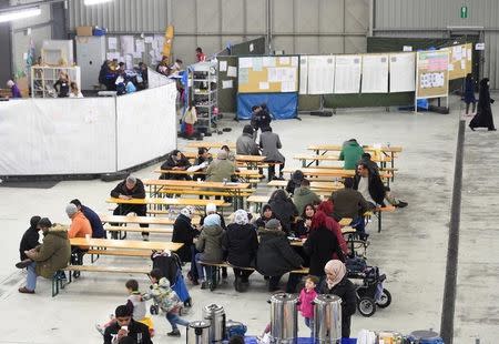 Migrants sit in a canteen in a refugee camp in Celle, Lower-Saxony, Germany October 15, 2015. REUTERS/Fabian Bimmer