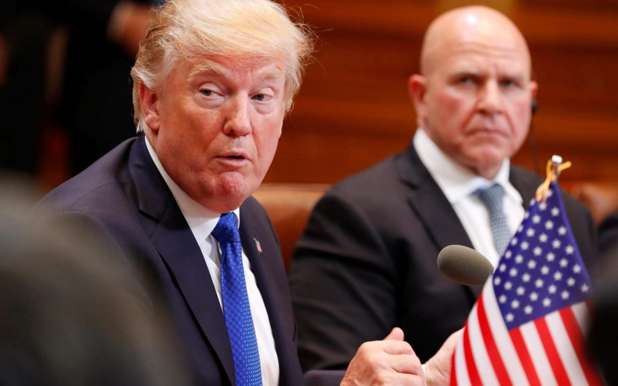 McMaster sits next to Donald Trump during a summit - AFP