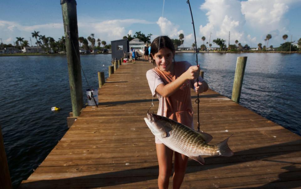 Ashlyn Florian shows off her catch at the Bokeelia Fishing Pier on the north end of Pine Island on Monday, July 31, 2023. The pier opened Monday after it was closed due to Hurricane Ian crushing Southwest Florida.