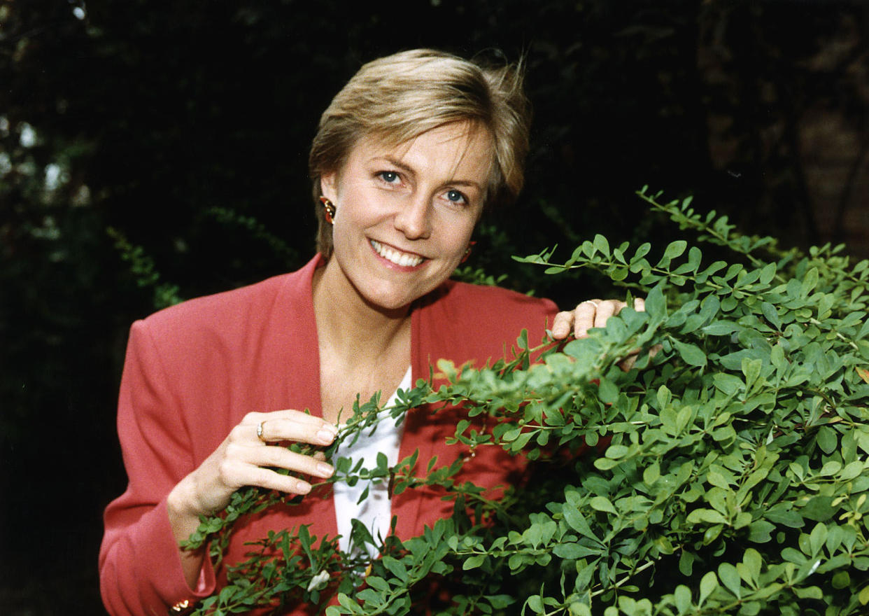 Jill Dando TV Presenter standing behind a bush