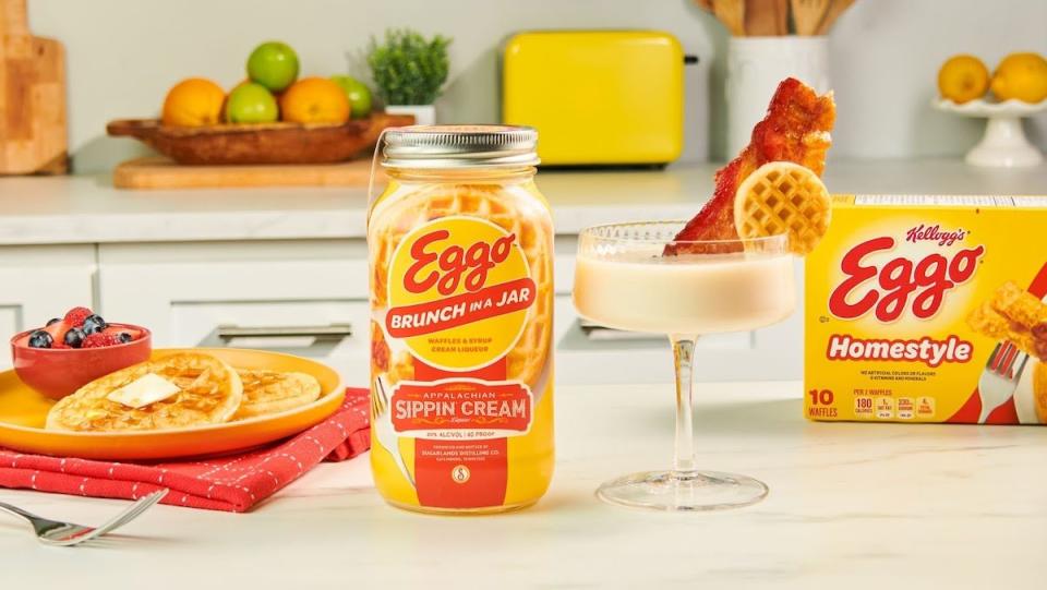 Eggo Brunch in a Jar Sippin Cream next to a cocktail, plate of pancakes, and a box of Eggo