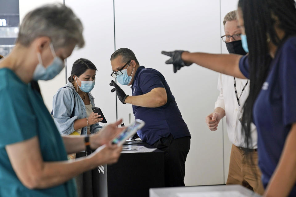 FILE — Staff at the Modern Museum of Art check visitors' proof of vaccination in New York, Sept. 13, 2021. Facing a winter surge in COVID-19 infections, New York Gov. Kathy Hochul says that masks will be required in all indoor public places unless the businesses or venues implement a vaccine requirement. (AP Photo/Seth Wenig, File)