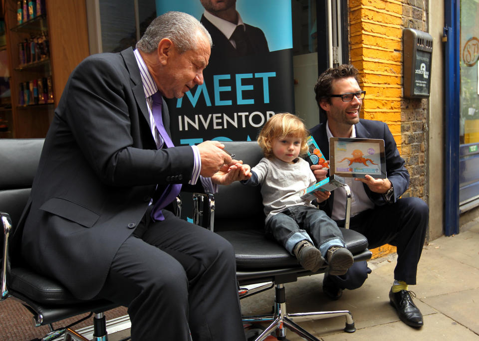 Lord Sugar and inventor Tom Pellereau, who won the 2012 series of The Apprentice, with Ren Butler aged two from Blackheath at a store in Convent Garden, London, during the unveiling of their latest product, a nail clipper for children.